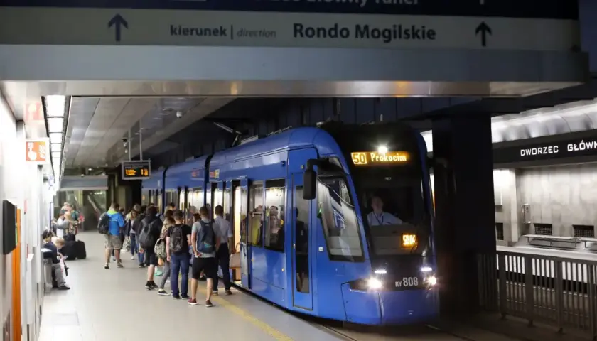 Tram 50 z Dworca Głównego w Krakowie do Prokocimia. Ludzie czekają na peronie.