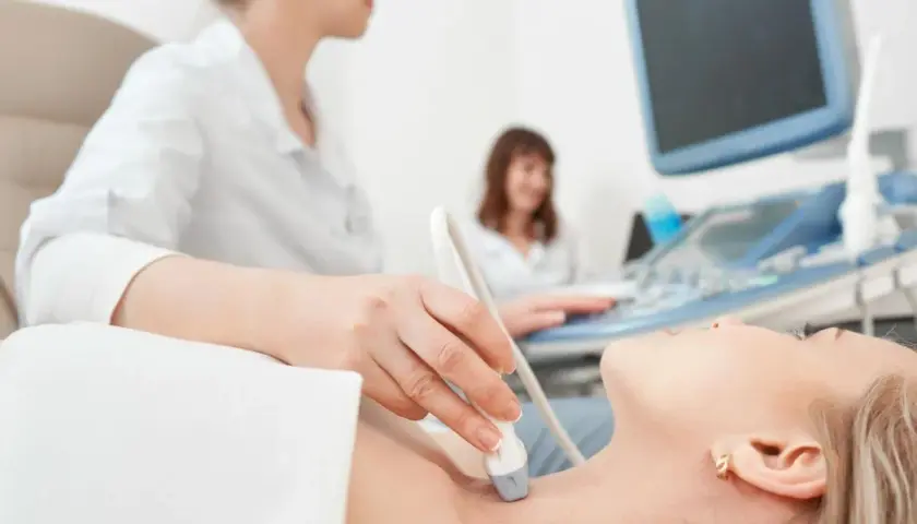 Ecografia tiroidea: un medico valuta la salute della paziente, un'indagine che può influenzare quanto guadagna un endocrinologo.