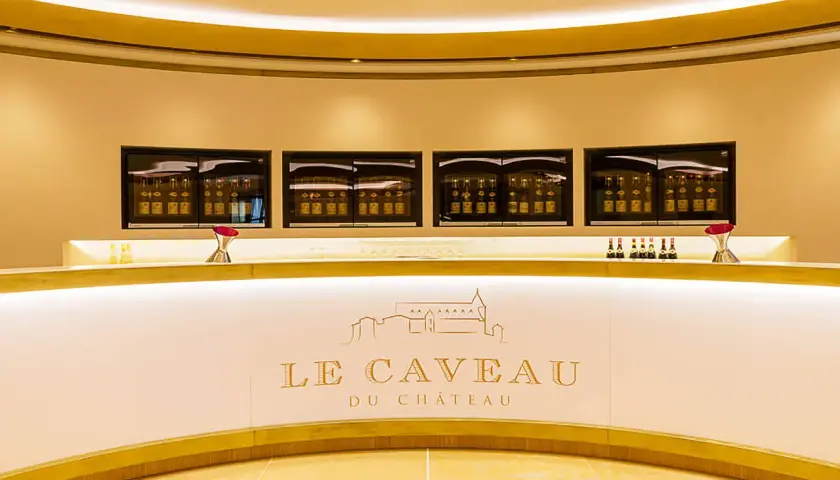 Le caveau Guigal, un comptoir moderne avec des bouteilles de vin exposées dans des vitrines lumineuses.