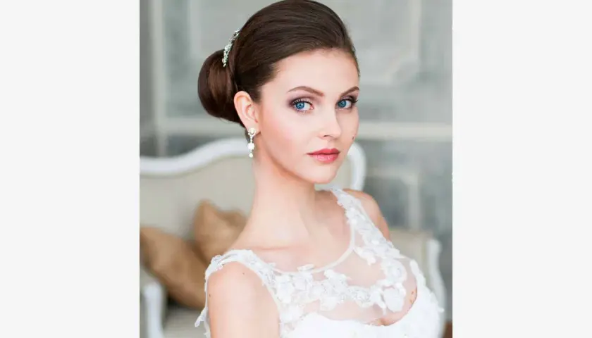 Panna młoda z eleganckim upięciem i biżuterią, w białej sukni.