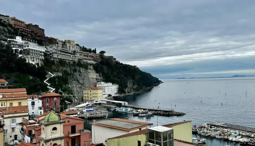Widok na malownicze miasteczko na klifie i port w Sorrento. Warto zobaczyć te kolorowe domy i błękitne morze.