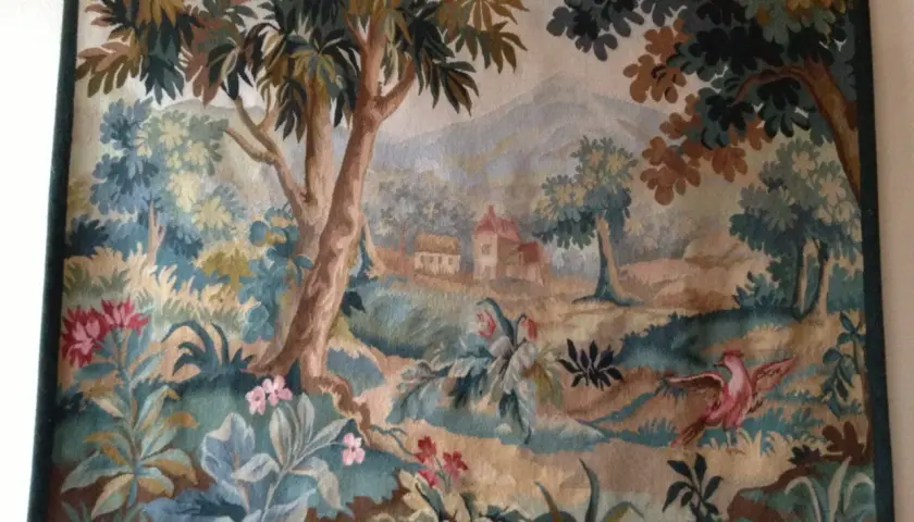 Magnifique toile d'Aubusson représentant un paysage champêtre avec des arbres, des fleurs et un oiseau rose en plein vol.
