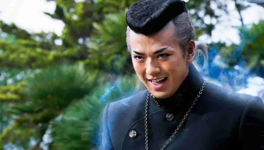 Un jeune homme au style unique, peut-être dans des films et séries TV avec Mackenyu, dégage une énergie mystérieuse.