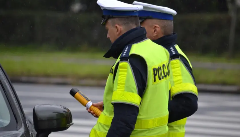 Policjant w kamizelce odblaskowej trzyma alkomat. Czy można odmówić dmuchania w alkomat? To pytanie zadaje sobie wielu kierowców.