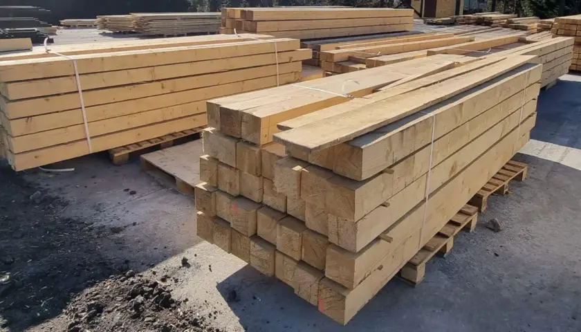 Stosy drewnianych belek, gotowe do transportu. Skład drewna machnik oferuje materiały budowlane najwyższej jakości.