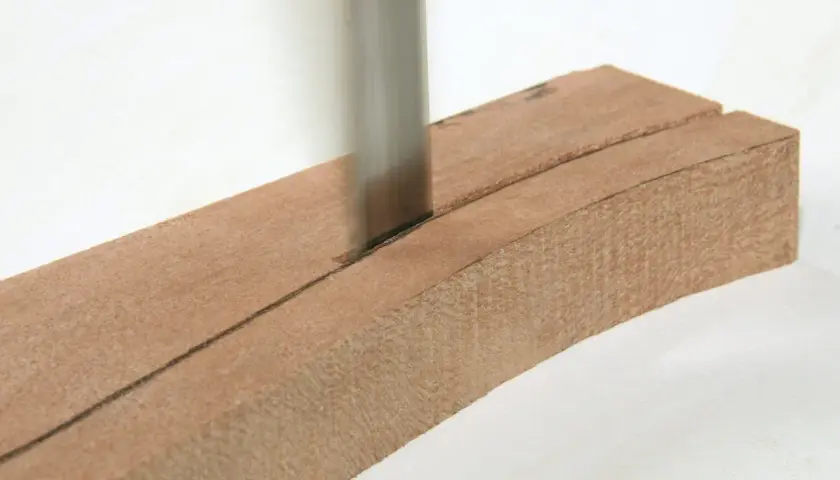 Ein scharfes Sägeblatt schneidet präzise durch ein Holzstück, das für eine Scheifele Bandsäge vorbereitet wird.