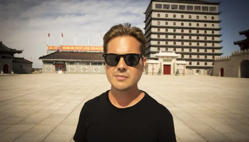 Christian Daun med solglasögon framför en asiatisk byggnad.
