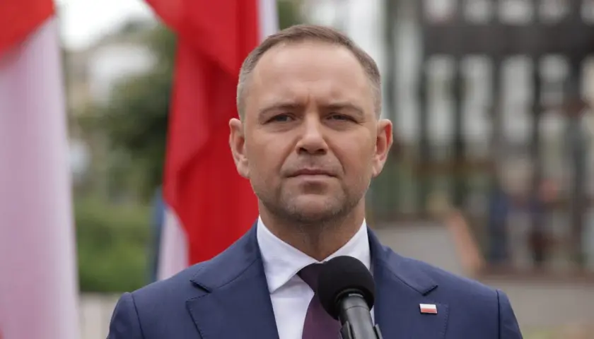 Prezydent w garniturze, obok flagi Polski, przemawia do mikrofonu. Czy prezydent może zablokować reformę renty wdowiej zaplanowaną na drugą połowę 2026 roku?
