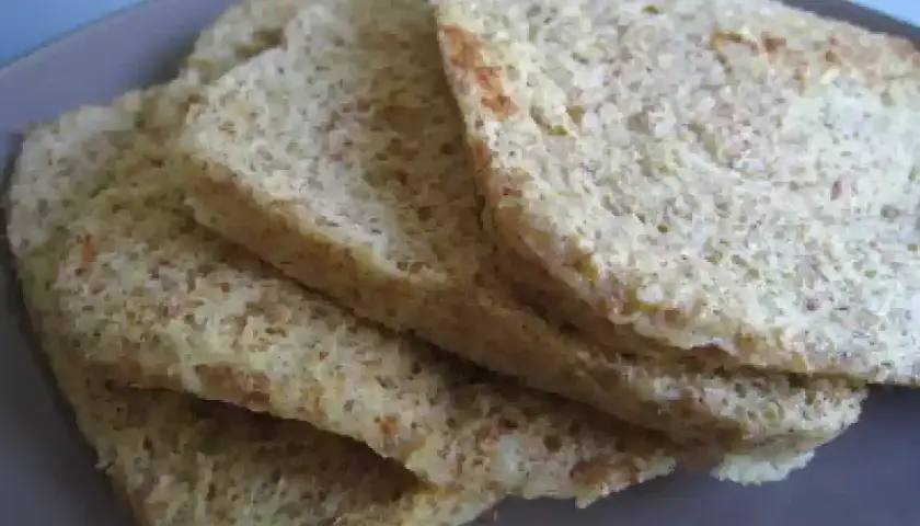 Tranches de pain au son d'avoine Dukan, légères et aérées, sur une assiette grise.