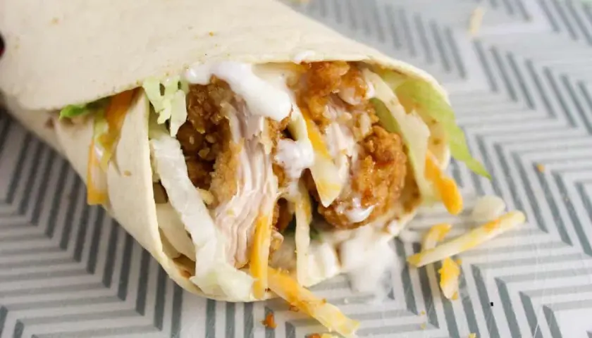 Klasyczny mcwrap z chrupiącym kurczakiem, serem i warzywami, polany sosem. Idealny na szybki posiłek, choć warto pamiętać o jego kcal.