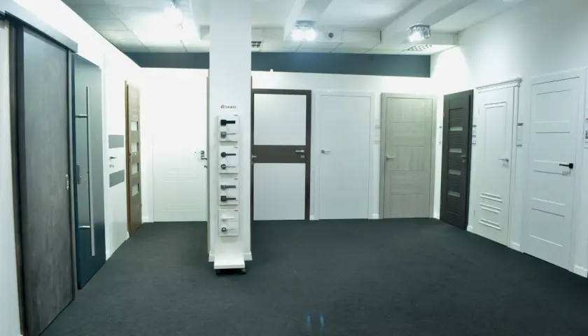 Salon z drzwiami i klamkami, prezentujący różne modele drzwi wewnętrznych i zewnętrznych.