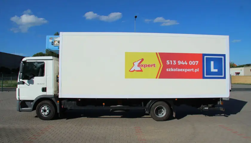 Biała ciężarówka z logo "X expert" i literą "L" na naczepie. To pojazd szkoleniowy kategorii C.
