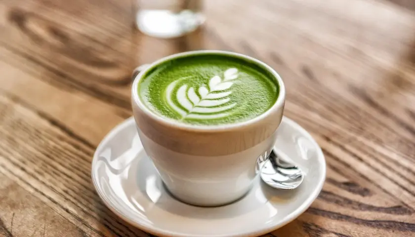 Tazza di matcha latte con schiuma decorata, un esempio di cos'è il latte in una bevanda cremosa e deliziosa.