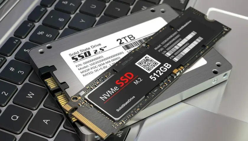 Dwa dyski SSD: 2.5" 2TB i M.2 NVMe 512GB, leżące na klawiaturze laptopa. Jaki dysk SSD do laptopa wybrać?