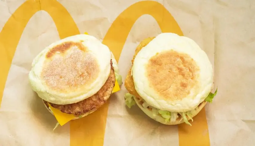 Dwa McMuffiny na papierze McDonald's. Jeden z kotletem i serem, drugi z chrupiącym kurczakiem i sałatą. Zastanawiasz się, co ma najmniej kalorii w Mc?