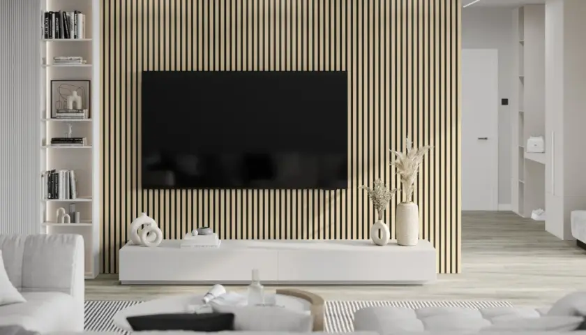 Nowoczesny salon z telewizorem na tle ściany z pionowych **lamelki**. Jasne meble i subtelne dekoracje tworzą przytulną atmosferę.