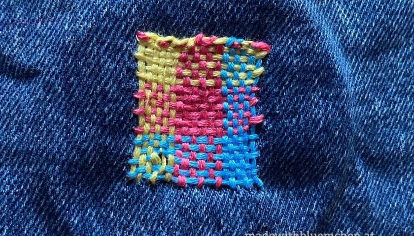 Buntes Quadrat aus Garn auf Jeansstoff, eine kreative kunststopfen anleitung.
