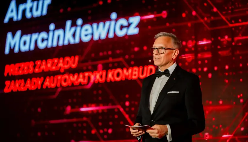 Artur Marcinkiewicz, prezes zarządu Zakłady Automatyki Kombud, przemawia na tle czerwonej scenografii.