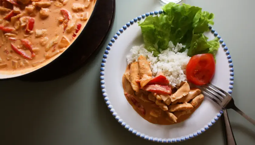 En krämig kyckling stroganoff med ris, sallad och tomat. En härlig middag som ser utsökt ut!