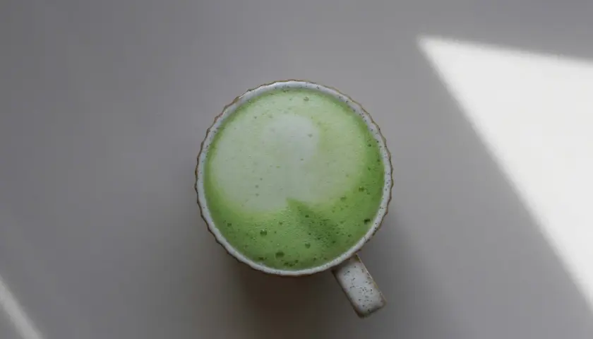 Eine Tasse cremiger Matcha-Latte, die die positive matcha wirkung psyche auf ruhige Weise unterstreicht.