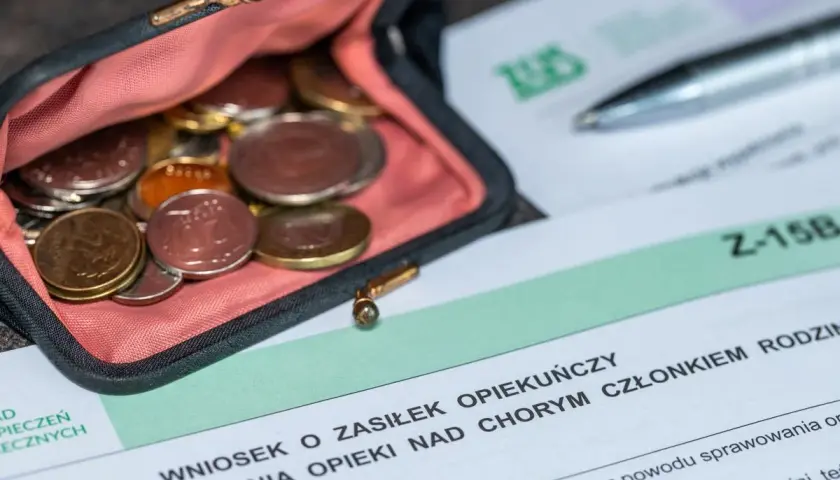 Portmonetka z monetami obok formularza "Wniosek o zasiłek opiekuńczy".