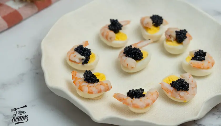 Deliciosos canapés con huevos de codorniz, camarones y caviar negro. Un bocado elegante y sabroso.