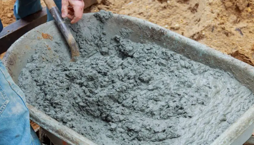 Mieszanie betonu B20 w taczce. Właściwe proporcje składników są kluczowe dla uzyskania wytrzymałego materiału budowlanego.