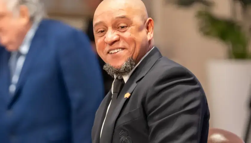 Uśmiechnięty Roberto Carlos w garniturze, z charakterystyczną brodą. Widać herb Realu Madryt. Roberto Carlos żyje i ma się dobrze!