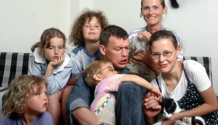 Olga Frycz z dziećmi i zwierzętami na kanapie. Wesoła rodzina z kotem i psem.