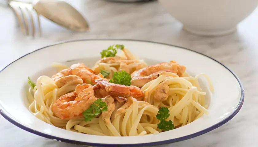 Pasta con jugosa salsa de langostinos, coronada con perejil fresco. Un plato delicioso y fácil de preparar.