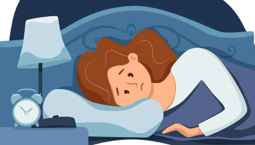 Eine Frau liegt wach im Bett, fragt sich, warum kann ich nicht einschlafen. Der Wecker auf dem Nachttisch zeigt die späte Stunde.