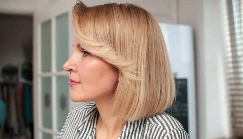 Kobieta z blond włosami w stylu french bob, w paski.