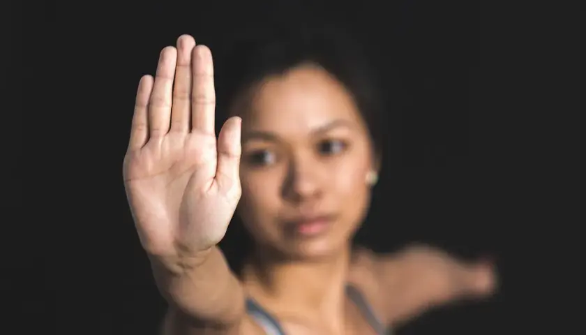Dłoń uniesiona w geście "stop". Kobieta gotowa do obrony koniecznej, gdy sytuacja tego wymaga.