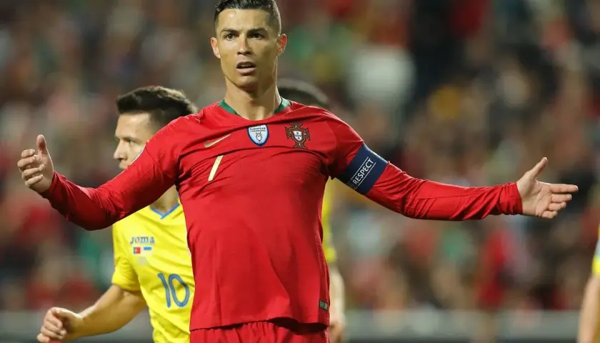 Cristiano Ronaldo w czerwonej koszulce Portugalii, z opaską "RESPECT", na tle drabinki rozgrywek Mistrzostw Europy w piłce nożnej.