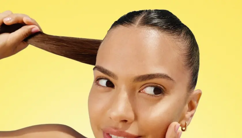 Mujer con cabello oscuro y liso, mostrando su brillo. ¡La vitamina C para el pelo es clave para un cabello radiante y saludable!