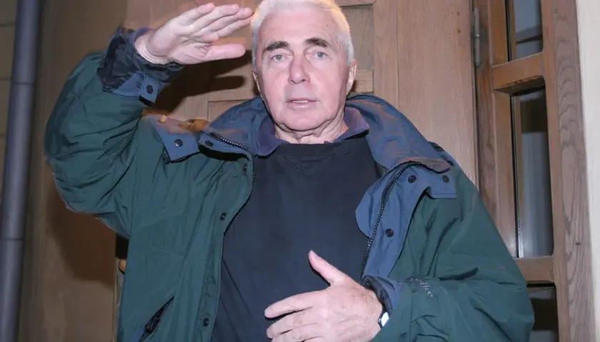 Marek Piwowarski reżyser, w zielonej kurtce, z ręką przy czole, jakby wypatrywał czegoś na horyzoncie.