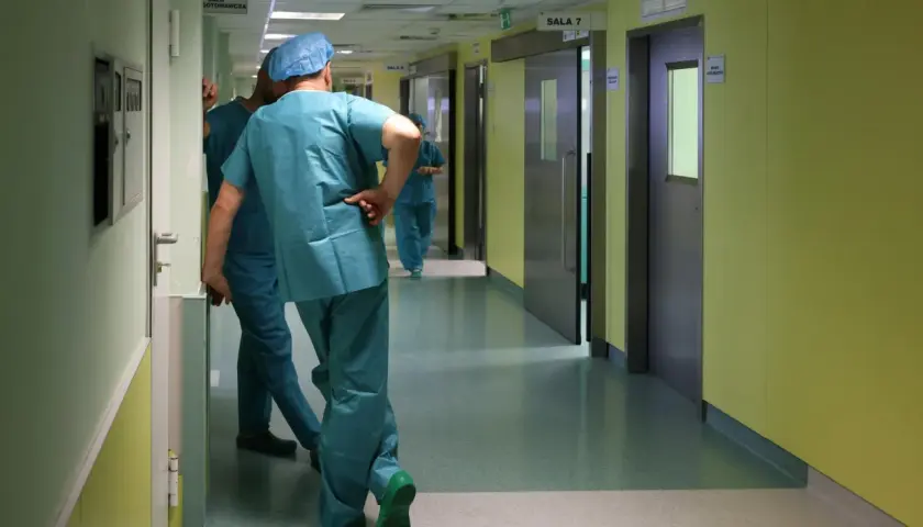 Lekarze w zielonych fartuchach idą korytarzem szpitalnym. Zastanawiasz się, ile zarabia lekarz?