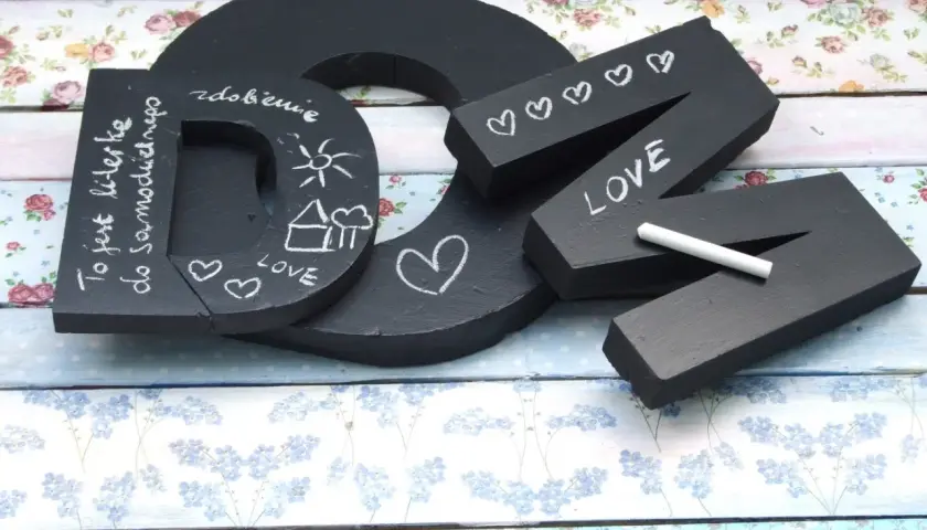Czarna litera "D" z napisem "To jest literka do samodzielnego..." i rysunkami. Obok litery "N" z napisem "LOVE" i serduszkami, wykonane w stylu pismo kaligraficzne.