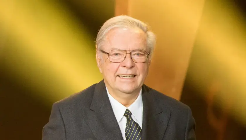 Uśmiechnięty Krzysztof Zanussi w garniturze, z okularami. Może opowiadać o swoich dzieciach.