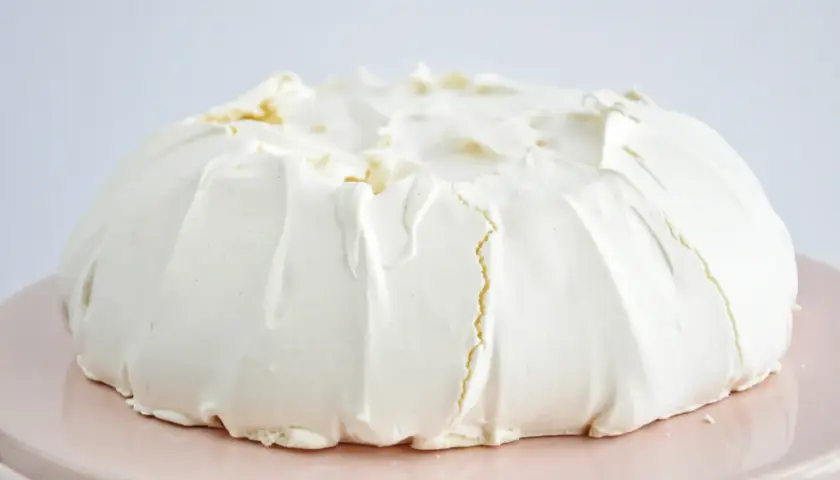 Puszysta beza pavlova z kremem, gotowa do dekoracji owocami.