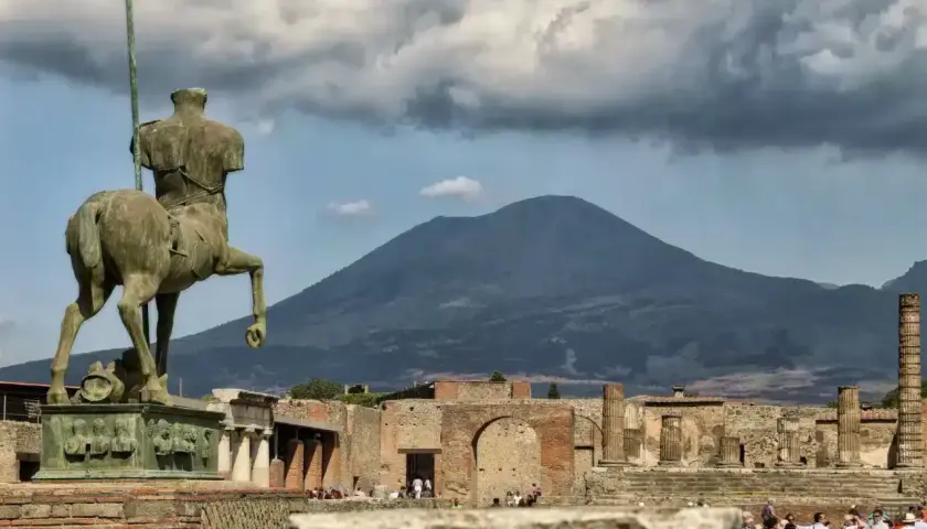 Statue équestre antique à Pompéi, avec le Vésuve en arrière-plan. Une visite de Pompéi inoubliable.