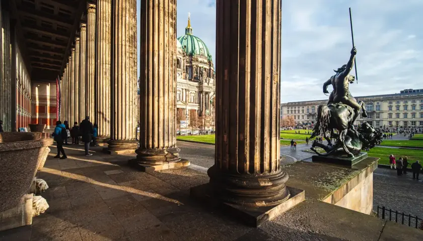 Niesamowite kolumny i rzeźba przed nowym muzeum w Berlinie. W tle widoczna kopuła katedry.