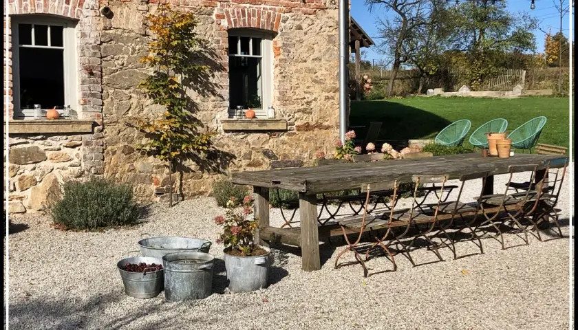 Rusty metal chairs await guests at a rustic table, perfect for enjoying the autumn charm of agroturystyka Dolny Śląsk.
