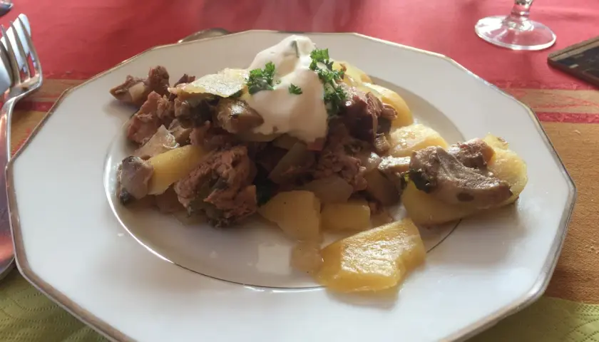 Un plat de baeckeoffe fumant, garni de crème et de persil. Quel vin avec baeckeoffe ? Un Riesling d'Alsace serait parfait.