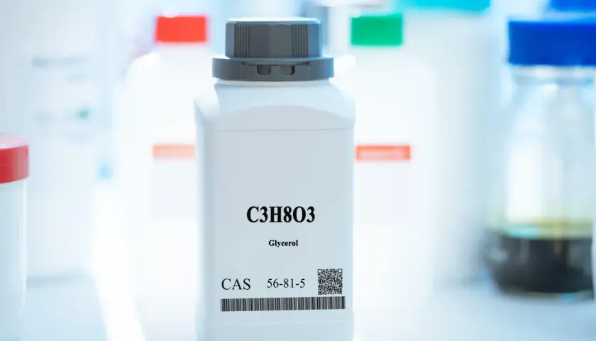 Biała butelka z gliceryną (C3H8O3), CAS 56-81-5. Choć e422 szkodliwość jest niska, należy zachować ostrożność.
