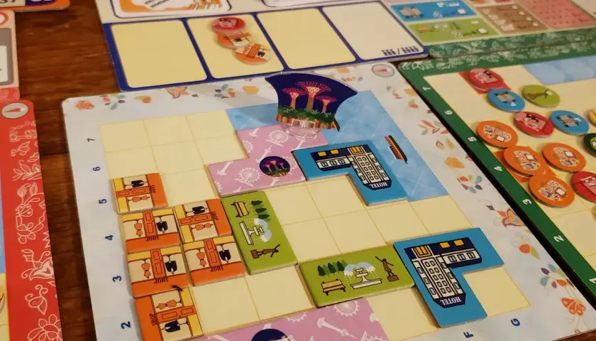 Bunte Spielbretter und Plättchen für deutsche Brettspiele. Mehrere Spieler legen ihre Züge auf dem Spielfeld ab.