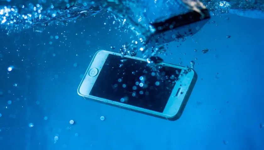Telefon zanurzony w wodzie. Zastanawiasz się, jak wysuszyć port USB? Szybko wyjmij go z wody i osusz.