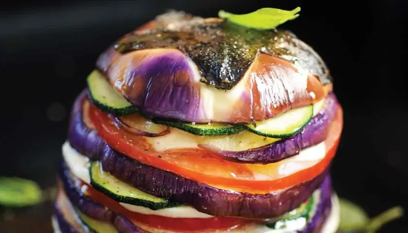 Délicieux légumes à la plancha, un empilement coloré d'aubergines, courgettes et tomates, avec une touche de pomme de terre cachée.