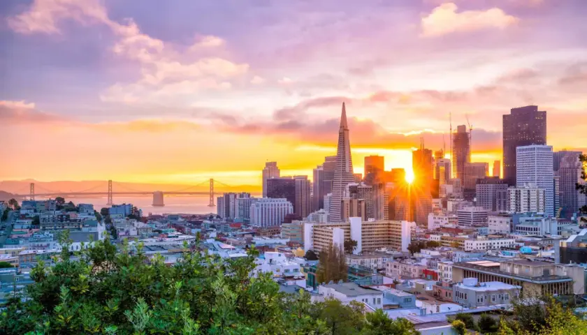 Widok na San Francisco o zachodzie słońca z mostem Golden Gate w tle.