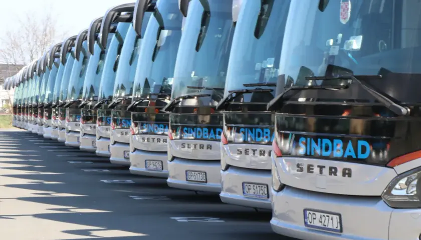 Rząd białych autokarów Sindbad, gotowych do podróży po Wielkiej Brytanii.